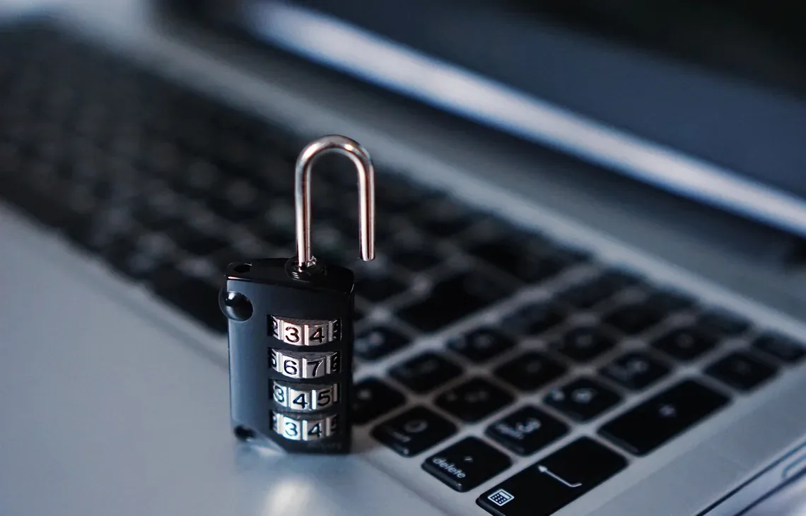 Otwarta kłódka na klawiaturze laptopa jako symbol usuwania wirusów i malware
